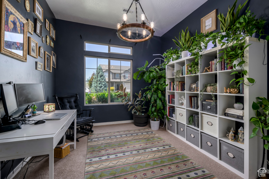 Carpeted office space featuring a chandelier and baseboards