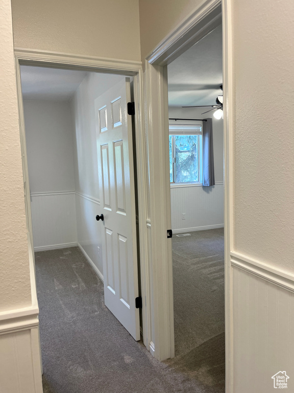 Hall featuring carpet floors and wainscoting