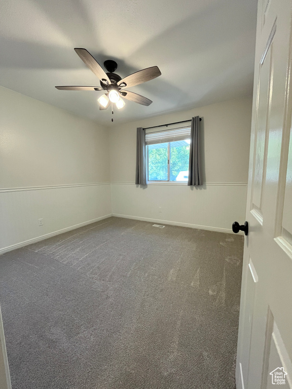 Unfurnished room featuring ceiling fan and carpet flooring