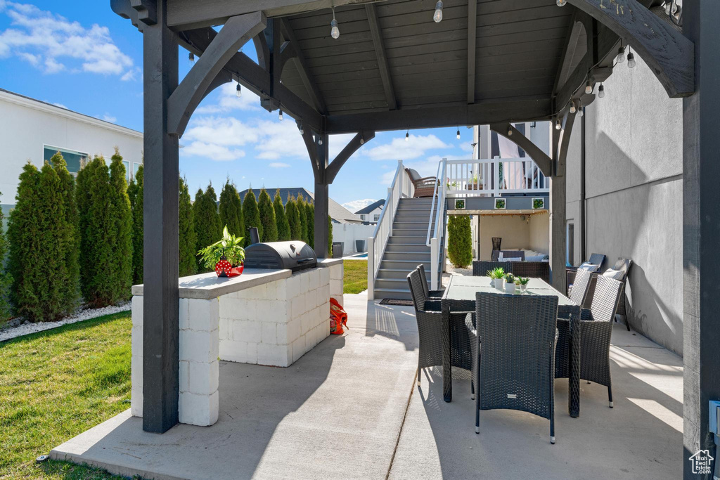 View of patio / terrace with stairway, outdoor dining area, and an outdoor kitchen