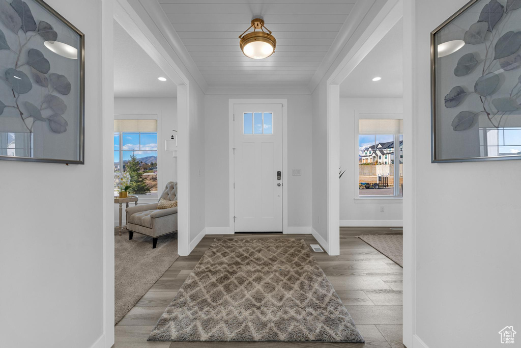 Foyer entrance featuring crown molding, wood finished floors, and recessed lighting