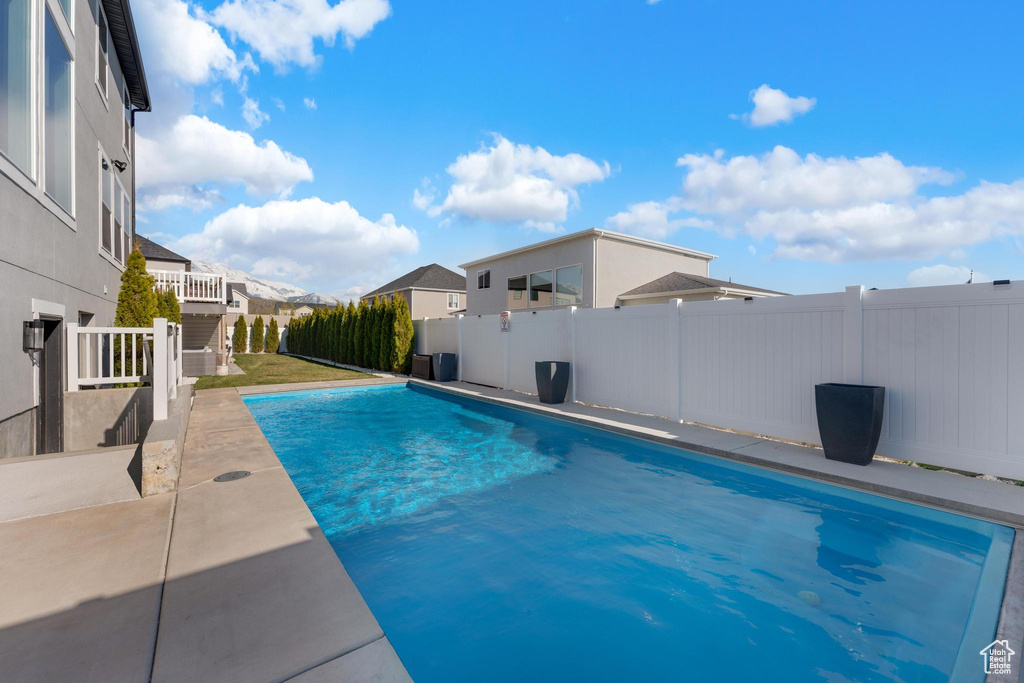 View of swimming pool with a fenced backyard, a patio, and a residential view