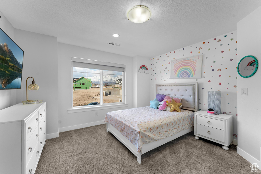 Carpeted bedroom featuring baseboards and a textured ceiling