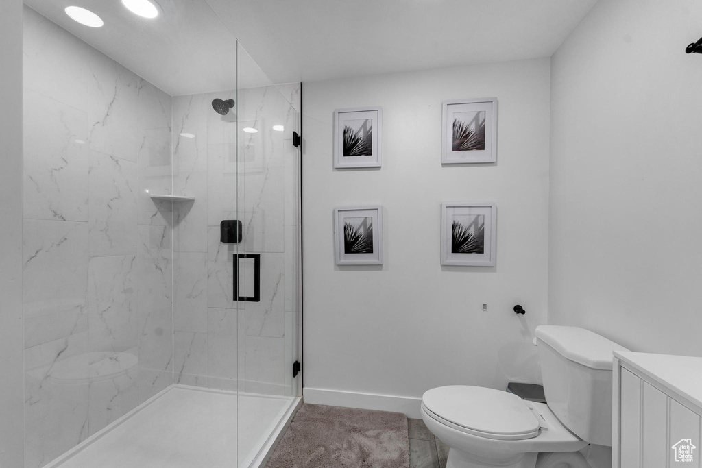 Full bath featuring a marble finish shower and vanity