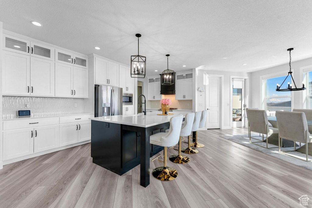 Kitchen featuring a chandelier, appliances with stainless steel finishes, light countertops, light wood finished floors, and recessed lighting