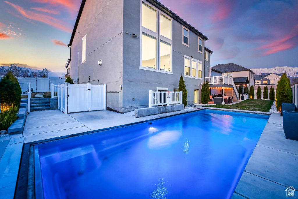 Outdoor pool with a gate, a fenced backyard, and a patio area