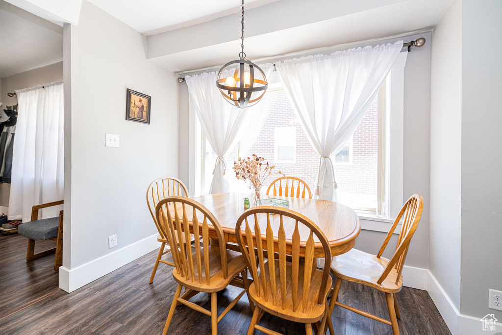Dining room featuring a chandelier, plenty of natural light, and dark wood-type flooring