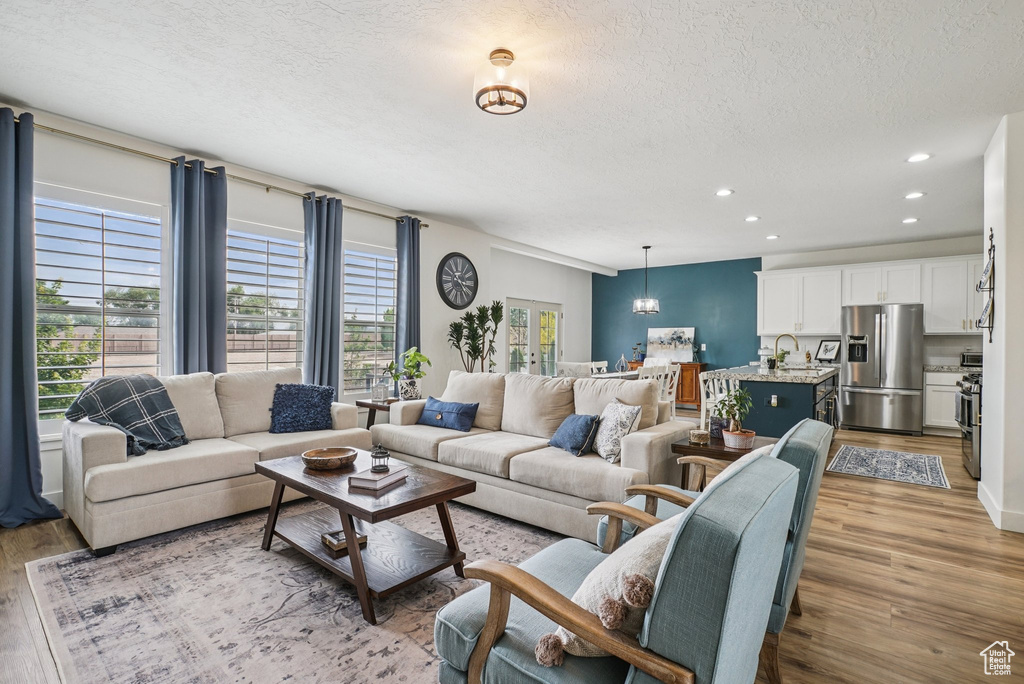 Living area featuring light wood-style floors, a textured ceiling, and recessed lighting
