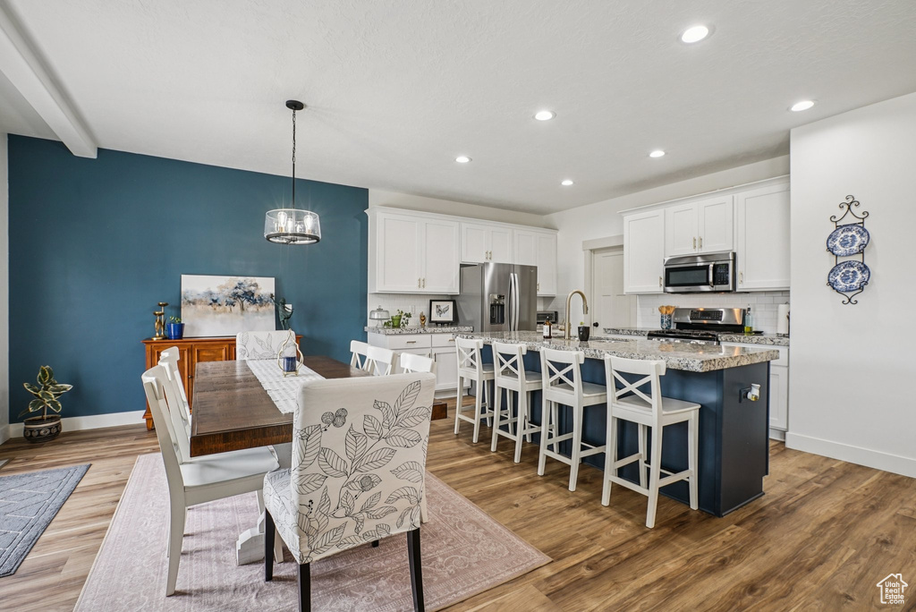 Dining area with wood finished floors, recessed lighting, and a chandelier