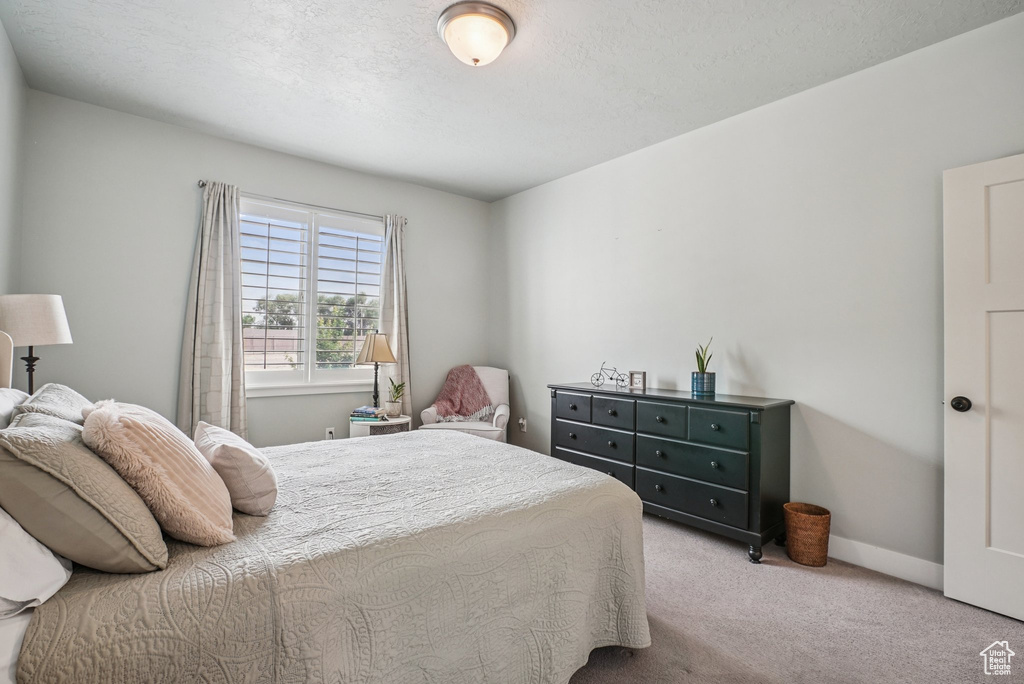Bedroom featuring carpet and baseboards