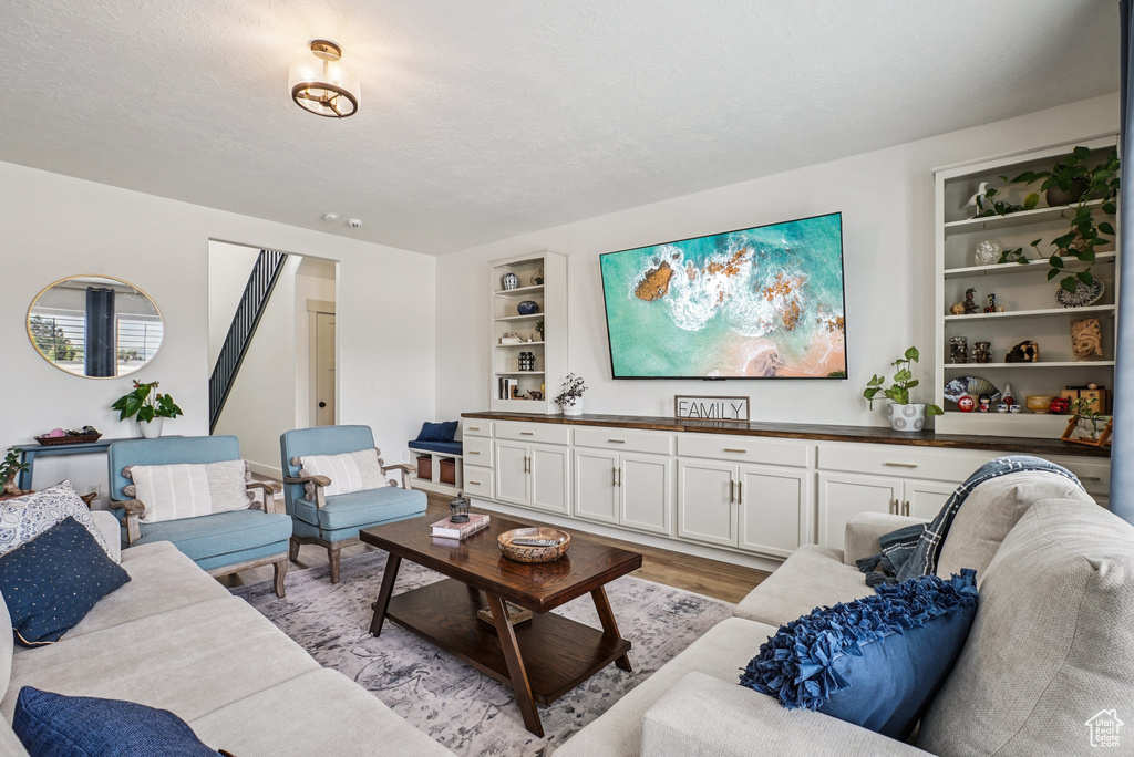 Living room with built in features and light wood finished floors