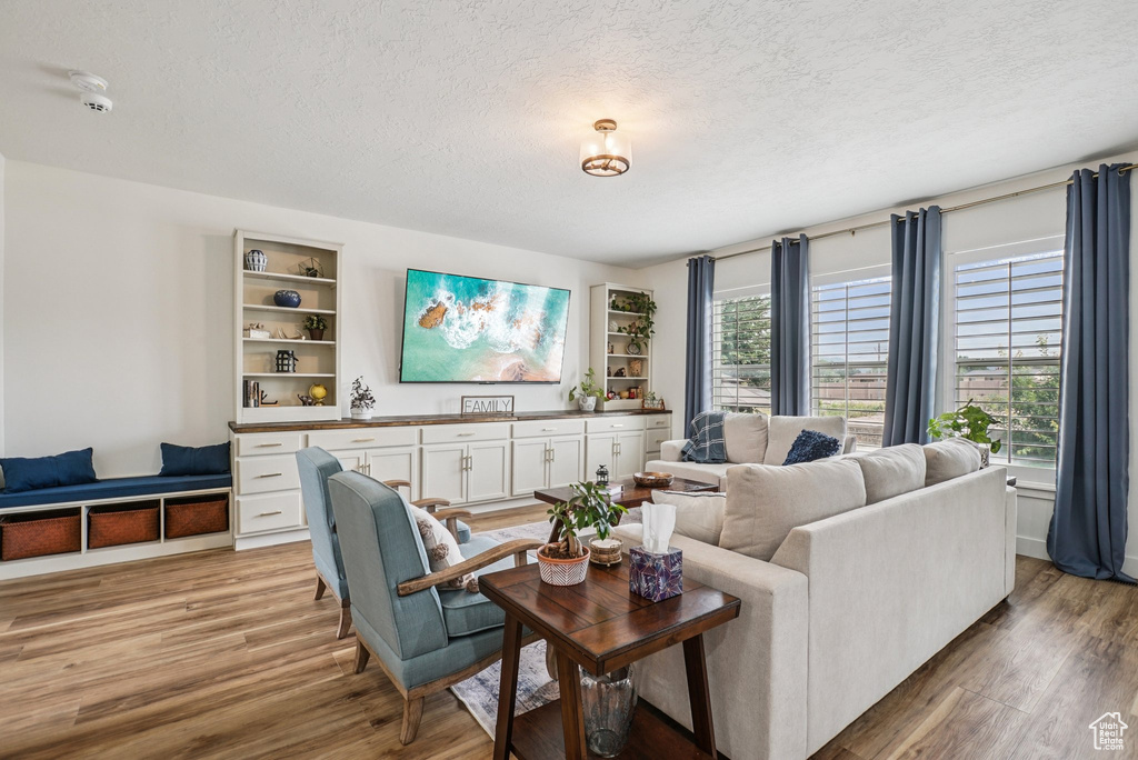 Living area with a textured ceiling and light wood-type flooring