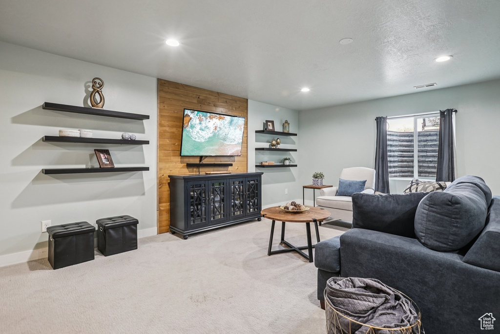 Living area with recessed lighting, carpet, and wooden walls