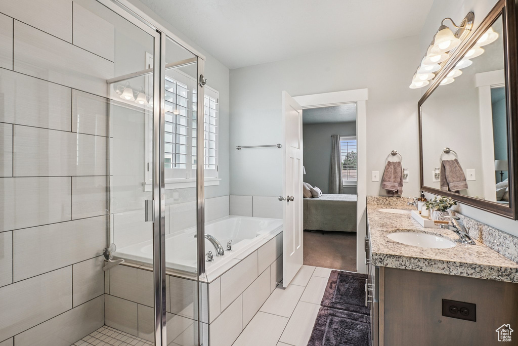 Ensuite bathroom with double vanity, tile patterned flooring, a garden tub, and a stall shower