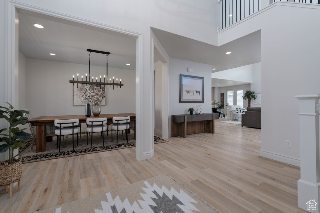 Entryway with wood finished floors, a chandelier, a high ceiling, and recessed lighting