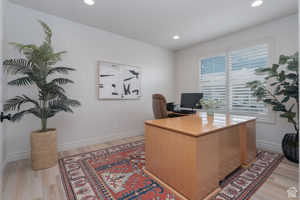 Home office with light wood-type flooring and recessed lighting