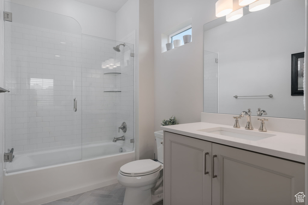 Bathroom featuring vanity and bath / shower combo with glass door