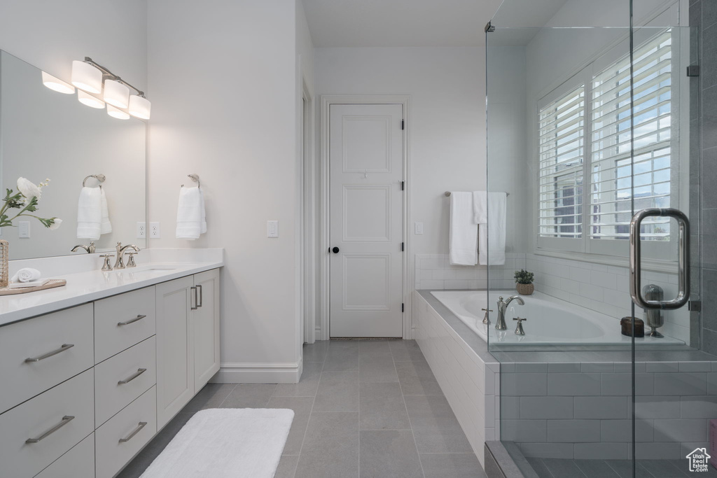 Full bath featuring vanity, a garden tub, tile patterned flooring, and a shower with door