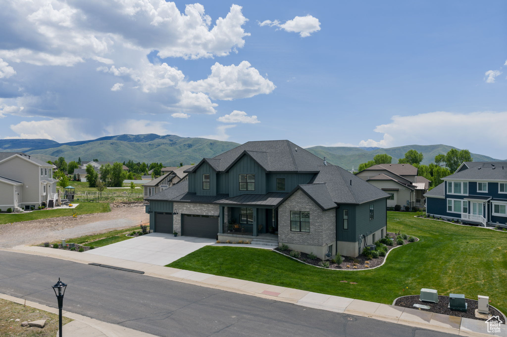 View of front of home with a mountain view, driveway, and a residential view