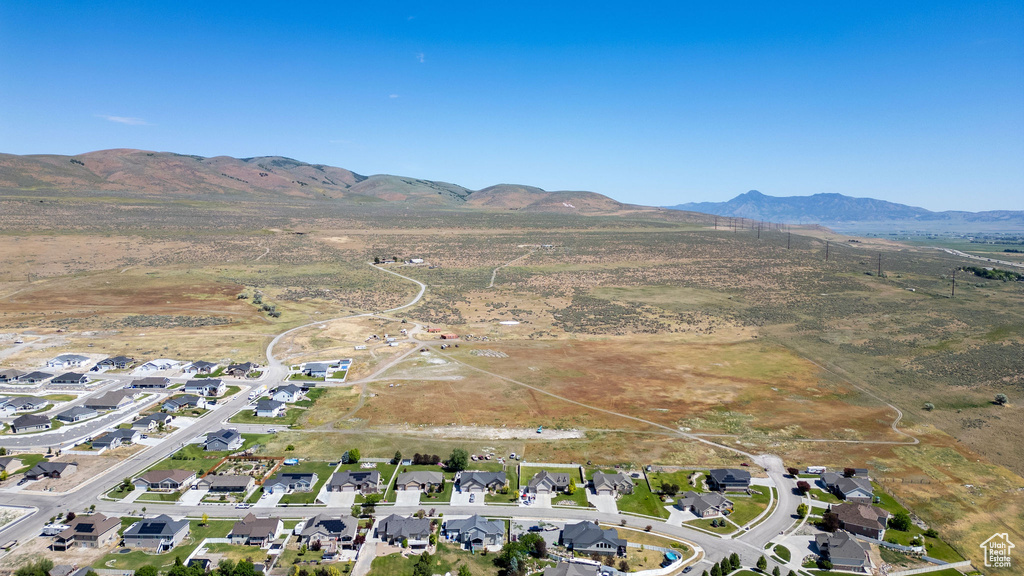 Aerial view of property and surrounding area with a mountainous background