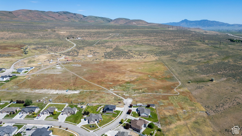 Aerial view of property and surrounding area featuring a mountainous background
