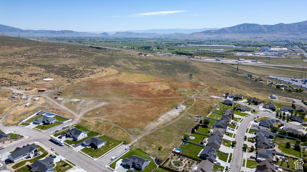 Aerial view of property and surrounding area with a mountain backdrop
