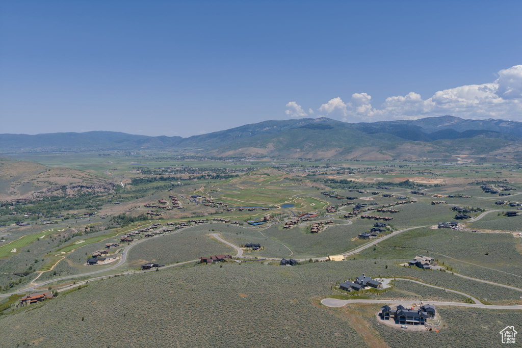 Aerial view of property and surrounding area featuring a mountainous background