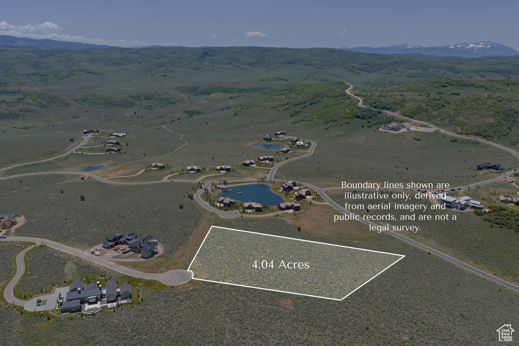 Aerial overview of property's location featuring a mountainous background and property parcel outlined