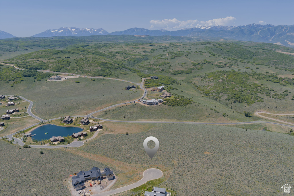 Aerial view of property and surrounding area featuring a water and mountain view
