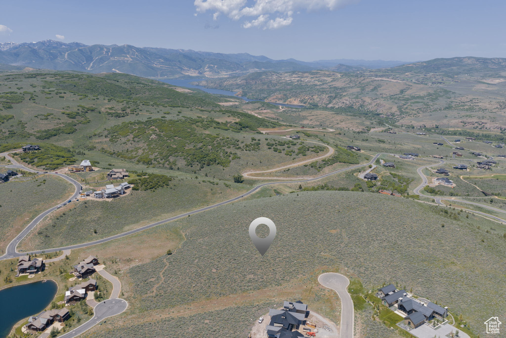 Aerial view of property and surrounding area featuring a water and mountain view