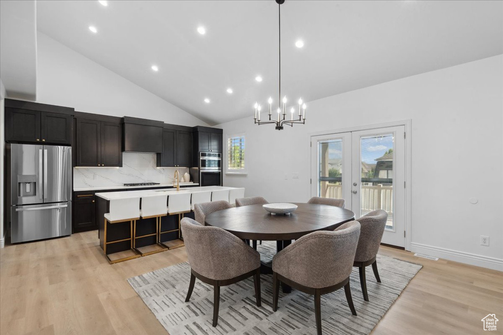 Dining room featuring a chandelier, light wood-style floors, high vaulted ceiling, and recessed lighting