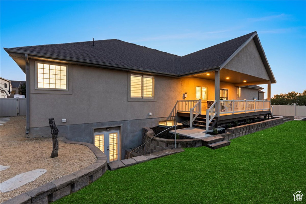 Rear view of property with french doors, a wooden deck, stucco siding, and a shingled roof