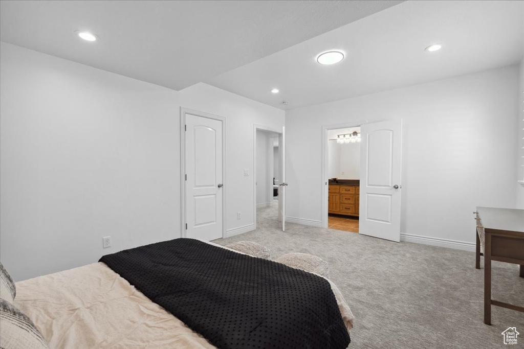 Bedroom with light colored carpet, recessed lighting, and ensuite bath