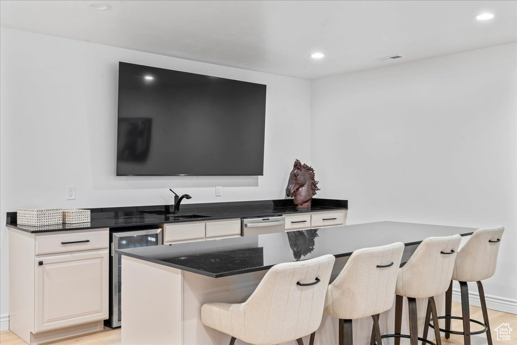 Kitchen featuring a breakfast bar, light wood-style flooring, recessed lighting, and a kitchen island