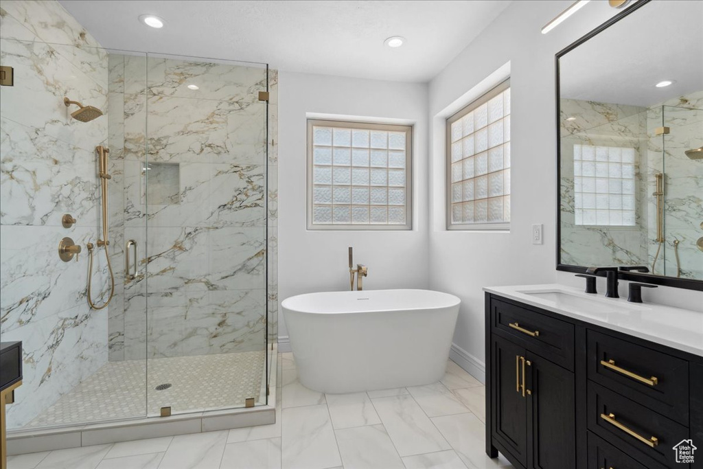 Bathroom featuring a marble finish shower, a soaking tub, vanity, marble finish floors, and recessed lighting