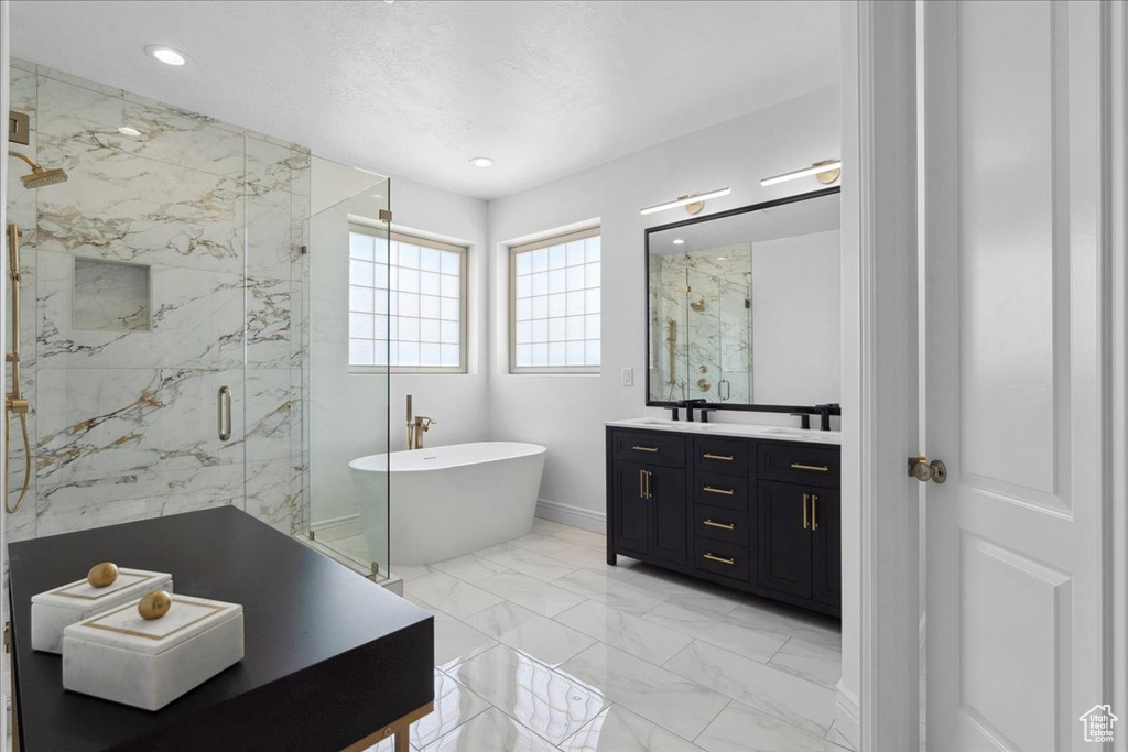 Bathroom featuring a marble finish shower, marble finish floors, a freestanding bath, vanity, and recessed lighting