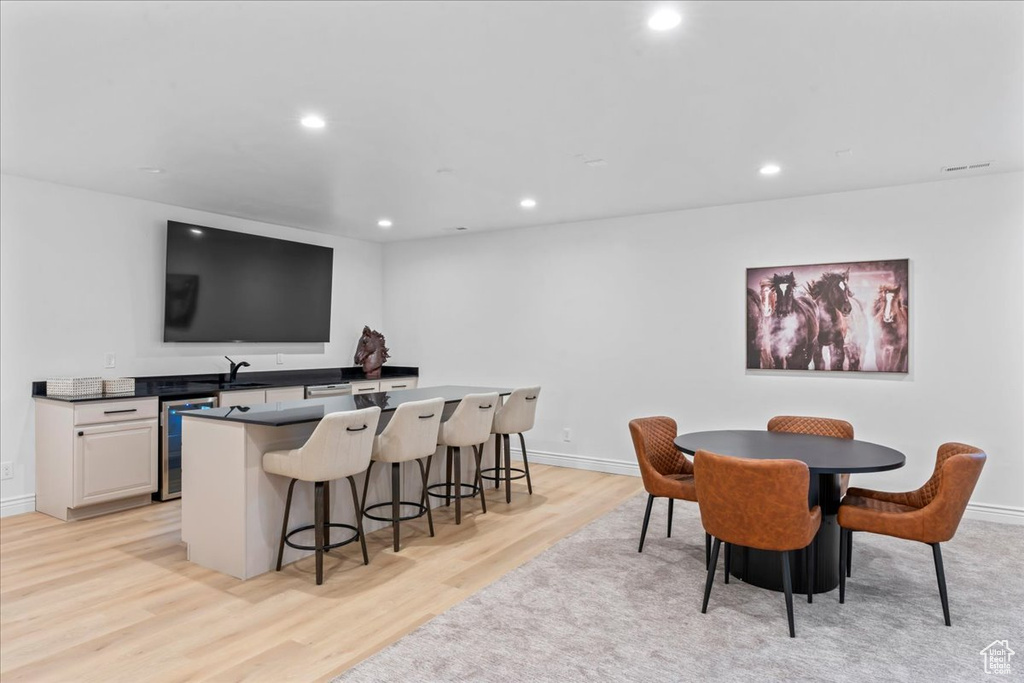 Dining space featuring wine cooler, light wood-style flooring, and recessed lighting