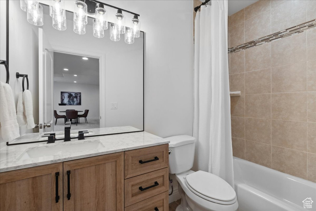 Full bathroom with vanity, shower / tub combo with curtain, and recessed lighting