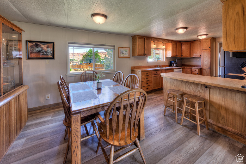 Dining space with light wood-style flooring and a textured ceiling