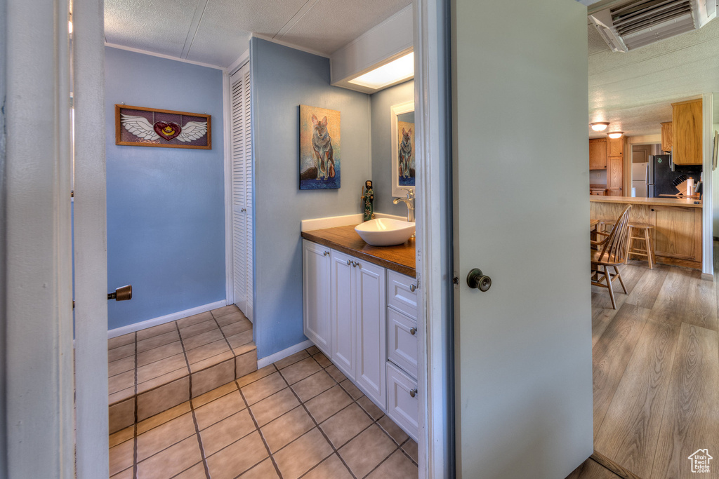 Bathroom with vanity, tile patterned flooring, and crown molding