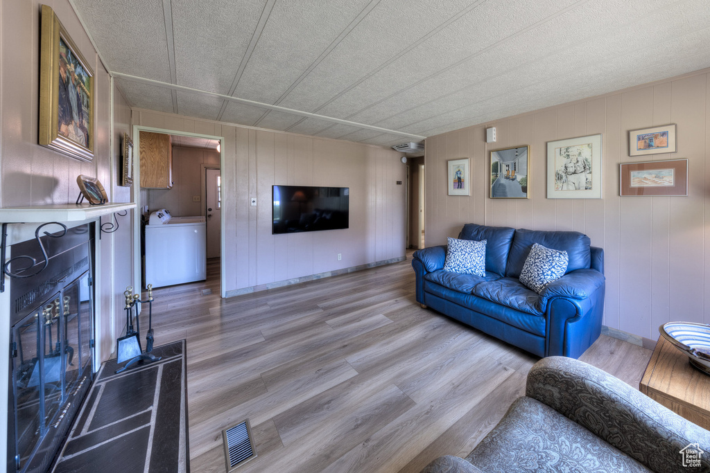 Living room with light wood finished floors and washer / dryer