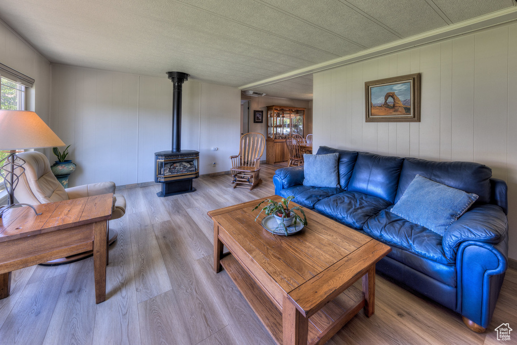 Living room with a wood stove and wood finished floors