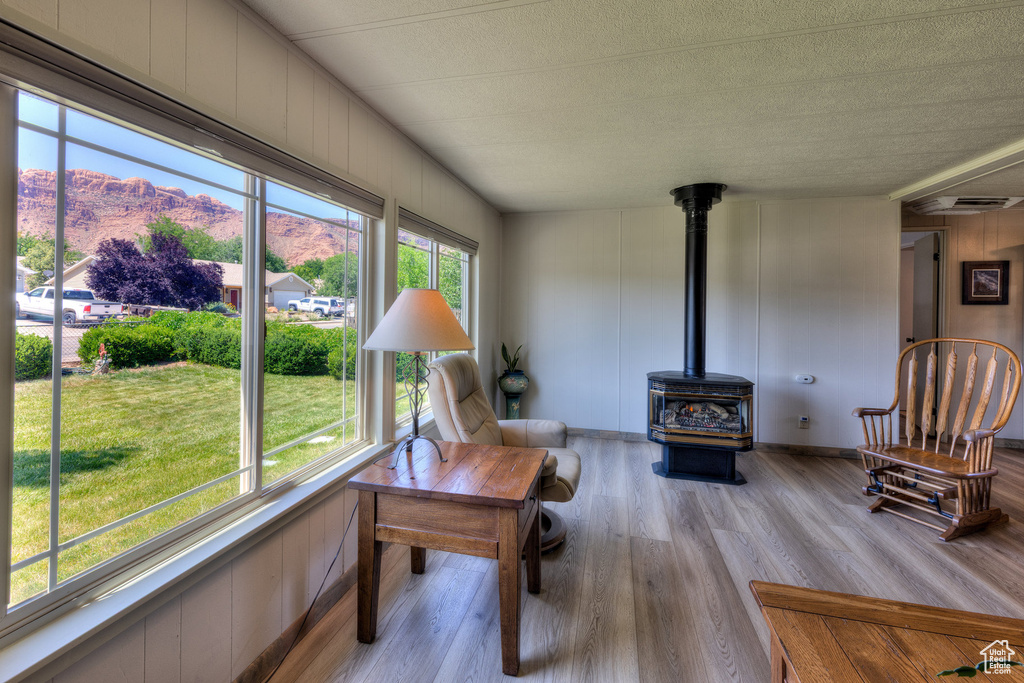 Living area with a mountain view, wood finished floors, a wood stove, and a textured ceiling