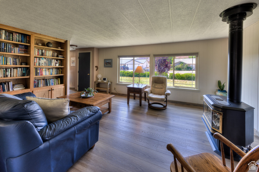 Living room with a wood stove and wood finished floors