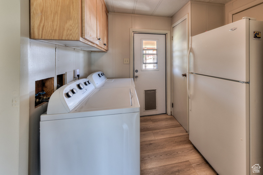 Washroom with washer and clothes dryer and light wood-style floors