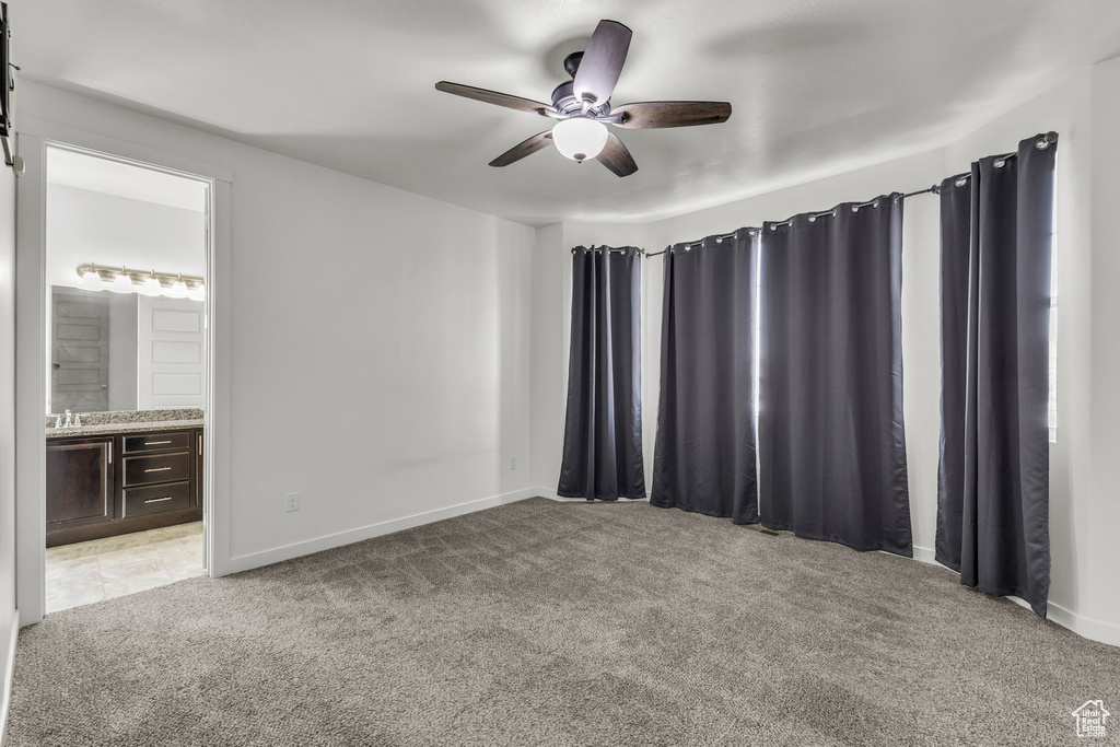 Empty room featuring light colored carpet and ceiling fan