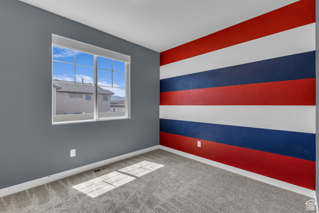 Empty room featuring carpet floors and baseboards