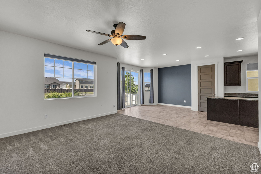 Unfurnished living room featuring ceiling fan, light tile patterned floors, recessed lighting, and light carpet
