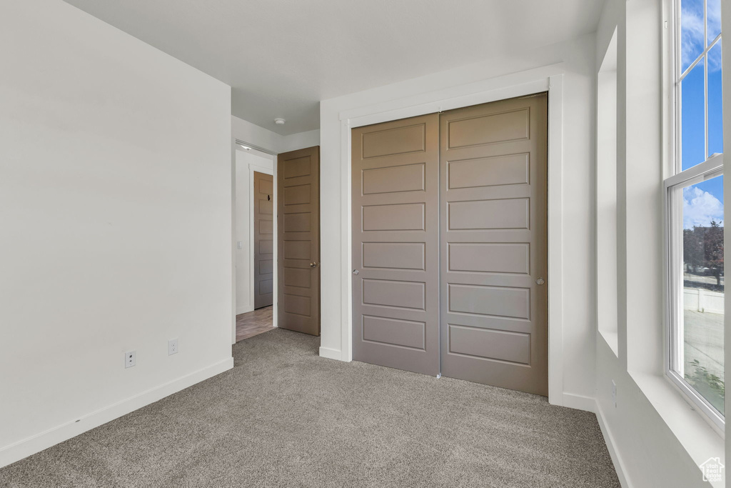Unfurnished bedroom featuring carpet and a closet