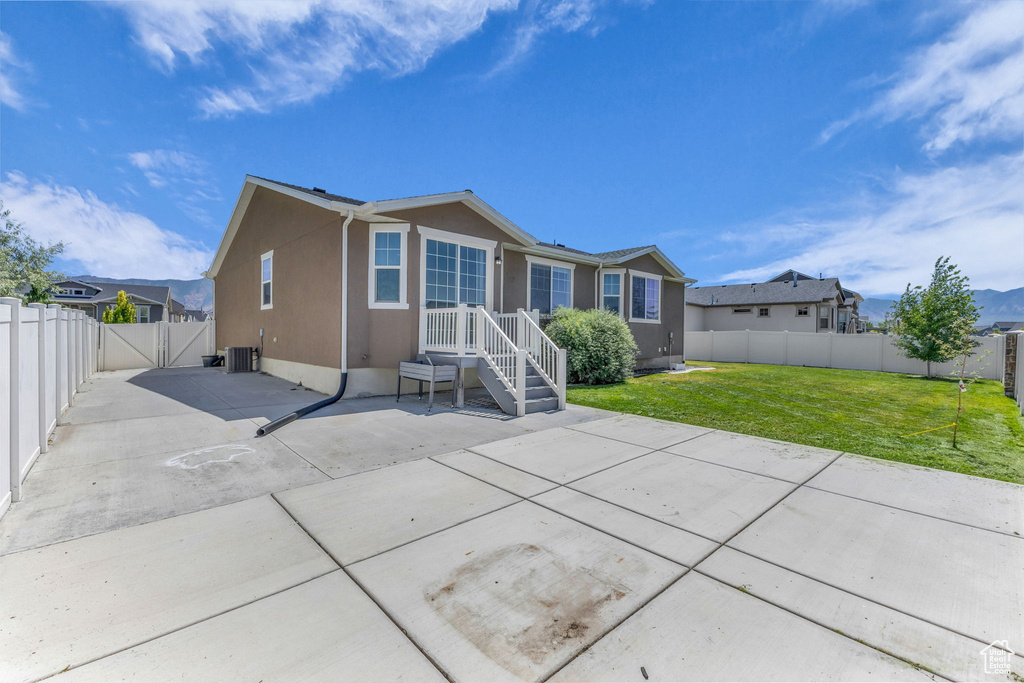 Back of house featuring a fenced backyard, a patio, stucco siding, and a gate